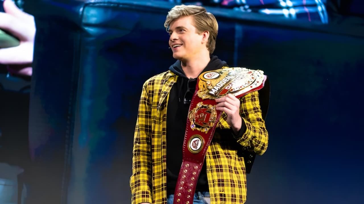 Kiv holding his Madden championship belt on stage.